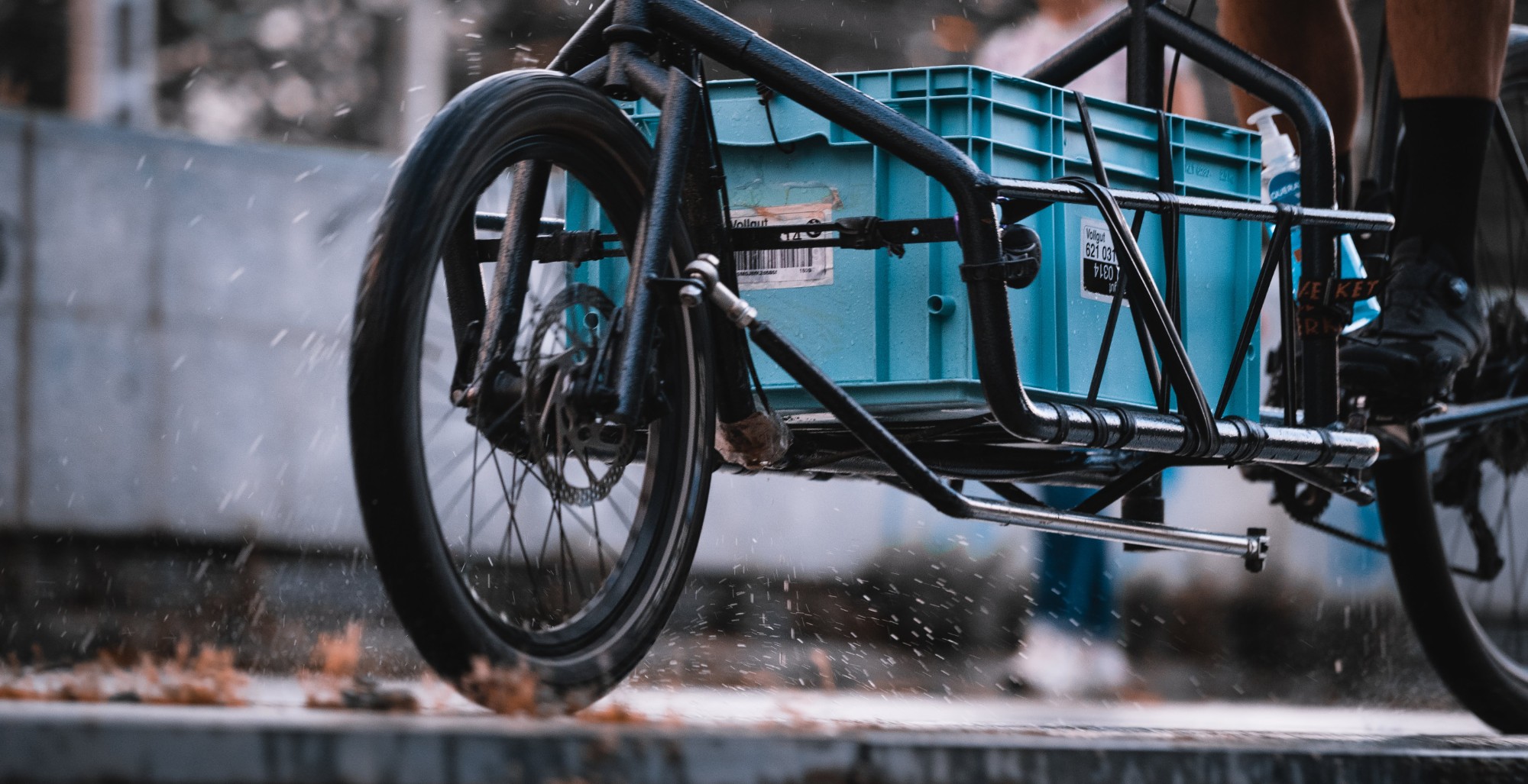 La rueda delantera de una bici de carga salpica agua